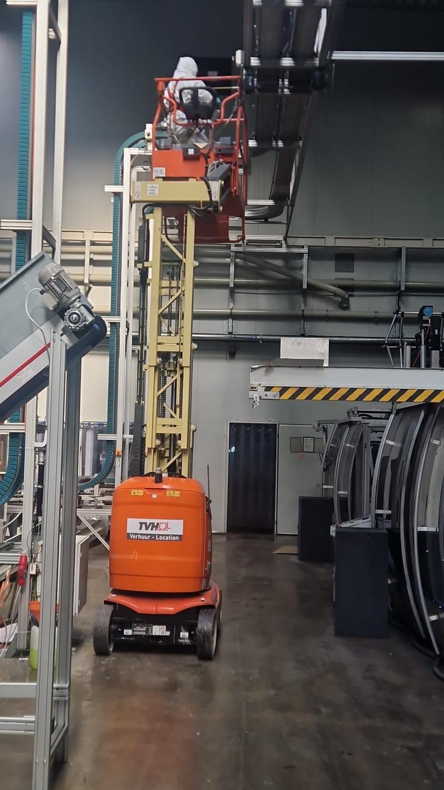 Specialist in een hoogtewerker tijdens industriële schoonmaak